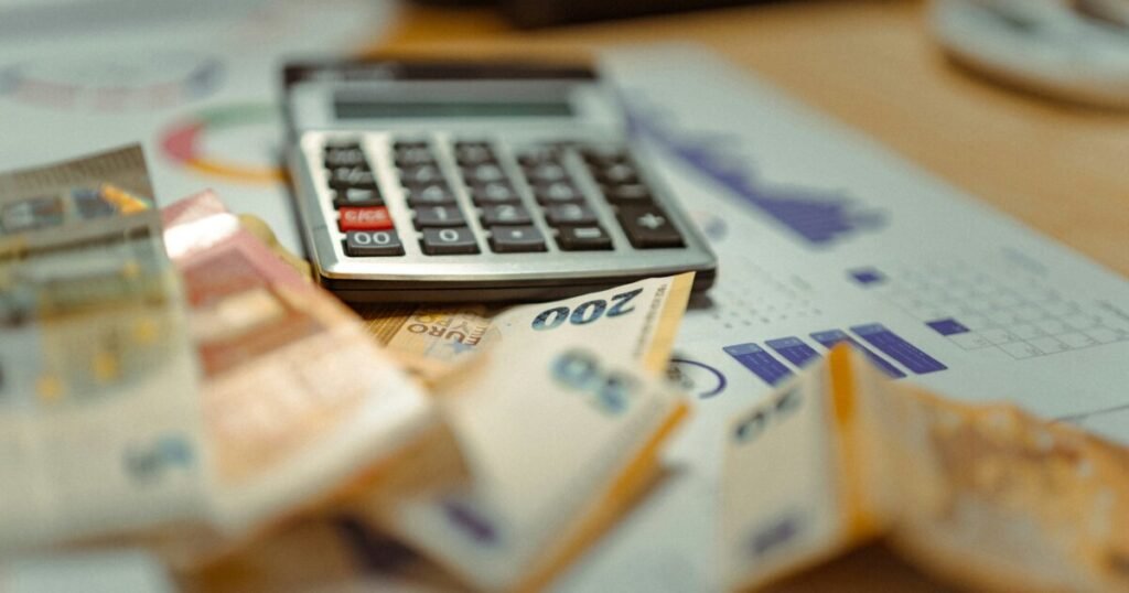 Calculator sitting on top of a pile of money representing laundry pricing