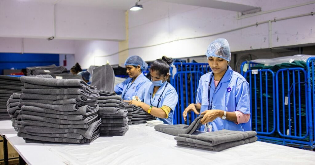 Workers folding clean towels for wash and fold laundry service